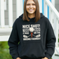 Woman wearing a black hoodie with a golf-themed design, standing outdoors.