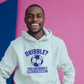 A man wearing a white hoodie with a funny football slogan on the front that reads 'Dribble You Can Barely Walk Straight!'