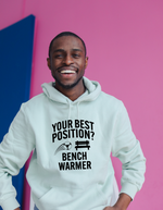 A man wearing a white hoodie that has the funny football slogan on the front that reads 'Your Best Position? Bench Warmer'