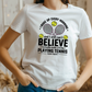 A lady wearing a white t-shirt with funny tennis slogan on the front that reads 'A white ceramic mug with tennis slogan on the front that reads 'I Wake Up Every Morning and Still Can’t Believe I Actually Make a Living Playing Tennis.'