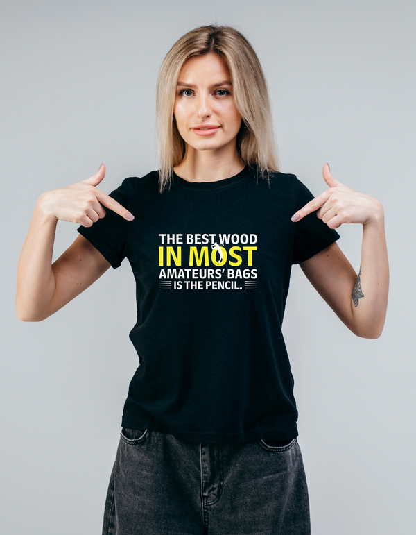 Woman wearing a black t-shirt with a humorous quote, pointing at the text with a Cows Corner slogan. The best wood in most amateurs' bags is the pencil.