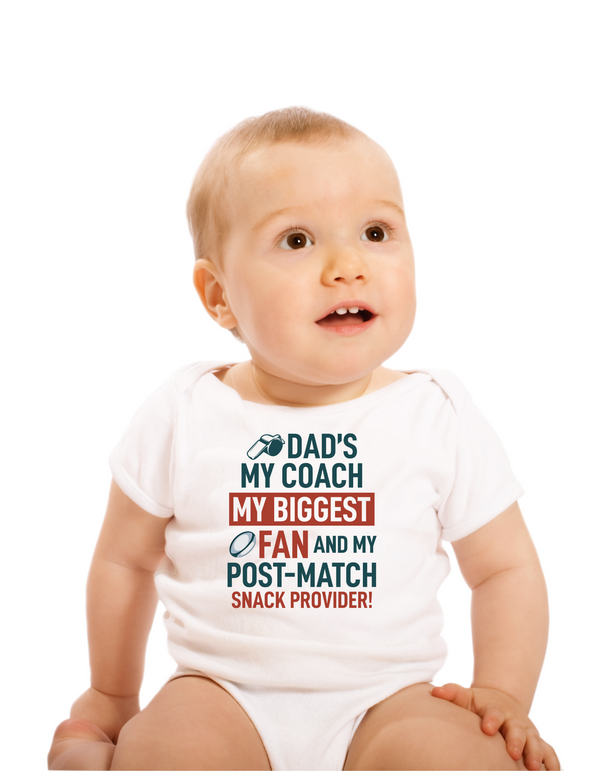 Baby wearing a white onesie with colorful text on a white background, with a slogan on the front saying 'Dad’s My Coach My Biggest Fan and My Post-Match Snack Provider!