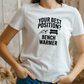 A lady wearing a white t-shirt that has the funny football slogan on the front that reads 'Your Best Position? Bench Warmer'