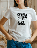 A lady wearing a white t-shirt that has the funny football slogan on the front that reads 'Your Best Position? Bench Warmer'
