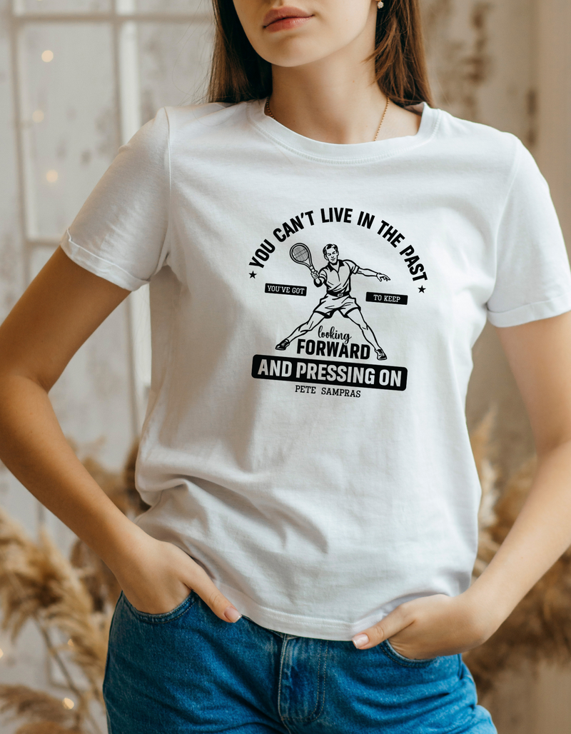 A white funny tennis t-shirt featuring the slogan on the front 'You Can’t Live in the Past, You’ve Got To Keep Looking Forward and Pressing On – Pete Sampras'