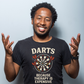Man wearing a black t-shirt with a dartboard graphic and text, against a light gray background with a Cows Corner slogan saying Darts because therapy is expensive.