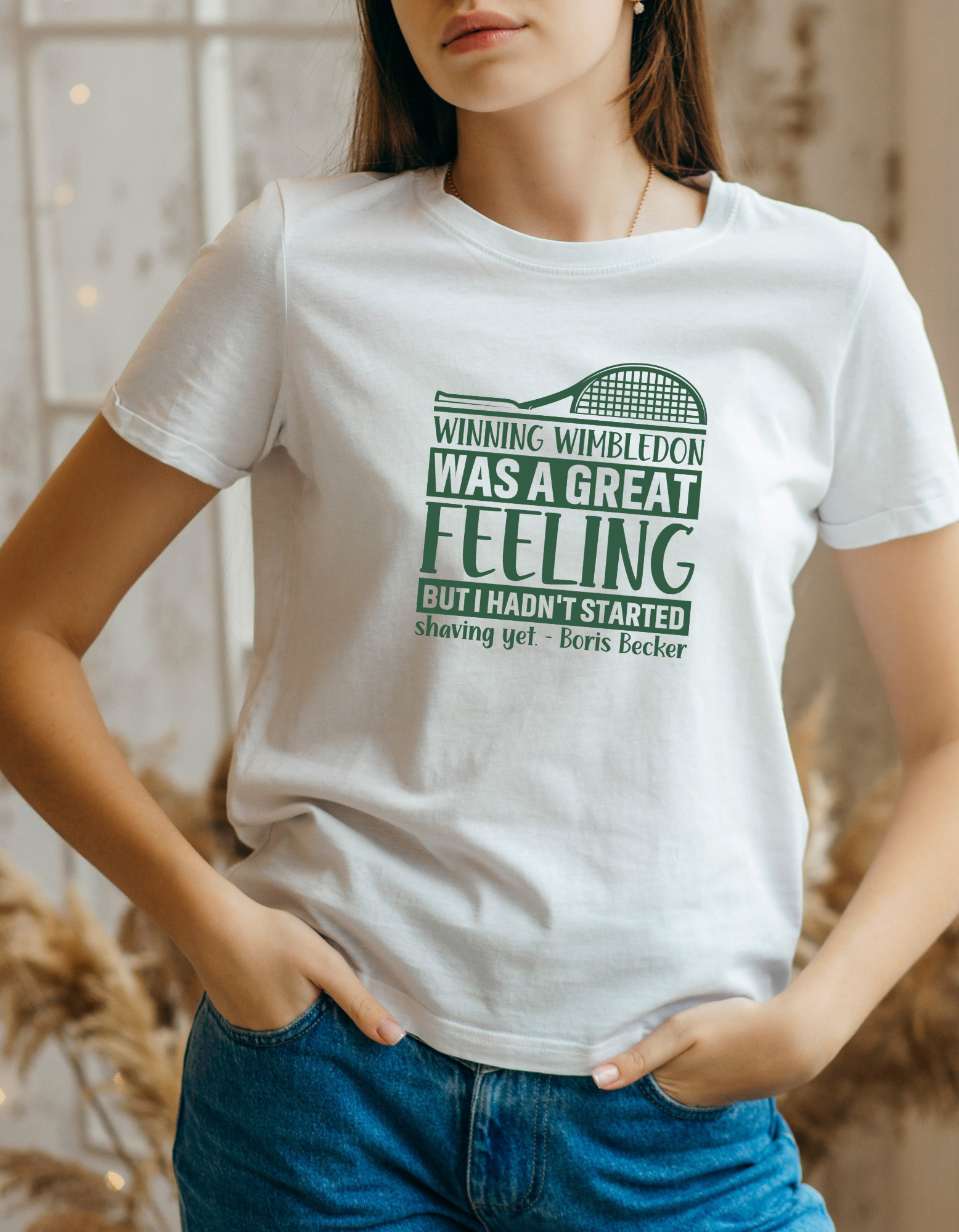 A lady wearing a white T-shirt with a funny tennis slogan on the front saying 'Winning Wimbledon Was a Great Feeling, but I Hadn’t Started Shaving Yet – Boris Becker'