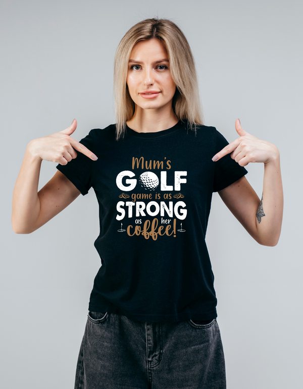 Woman wearing a black t-shirt with text pointing to herself against a gray background with a Cows Corner slogan saying Mums golf game is as strong as her coffee.