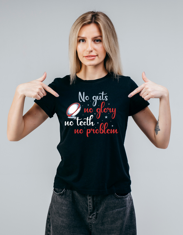 Woman wearing a black t-shirt with humorous text design on a plain background with a Cows Corner slogan saying No guts no glory, no teeth no problem