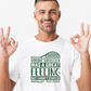 A man wearing a white T-shirt with a funny tennis slogan on the front saying 'Winning Wimbledon Was a Great Feeling, but I Hadn’t Started Shaving Yet – Boris Becker'
