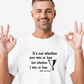 A man wearing a white t-shirt with the funny tennis slogan on the front reading 'It’s Not Whether You Win or Lose but Whether I Win or Lose – Billie Jean-King!