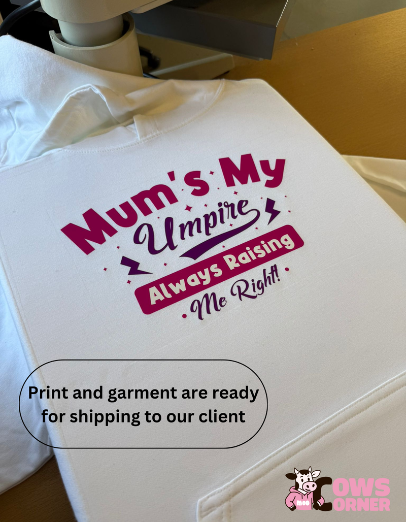 White Hoodie with 'Mum's My Umpire Always Raising Me Right!' text printed on it, ready for shipping from Cows Corner