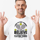 A man wearing a white t-shirt with funny tennis slogan on the front that reads 'A white ceramic mug with tennis slogan on the front that reads 'I Wake Up Every Morning and Still Can’t Believe I Actually Make a Living Playing Tennis.'
