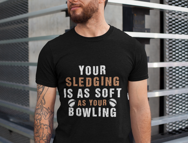 A man wearing a black t-shirt with Your Sledging Is As Soft As Your Bowling on the front. A Funny Cricket T-Shirt, Premium Fabric, Multiple Adult Sizes

