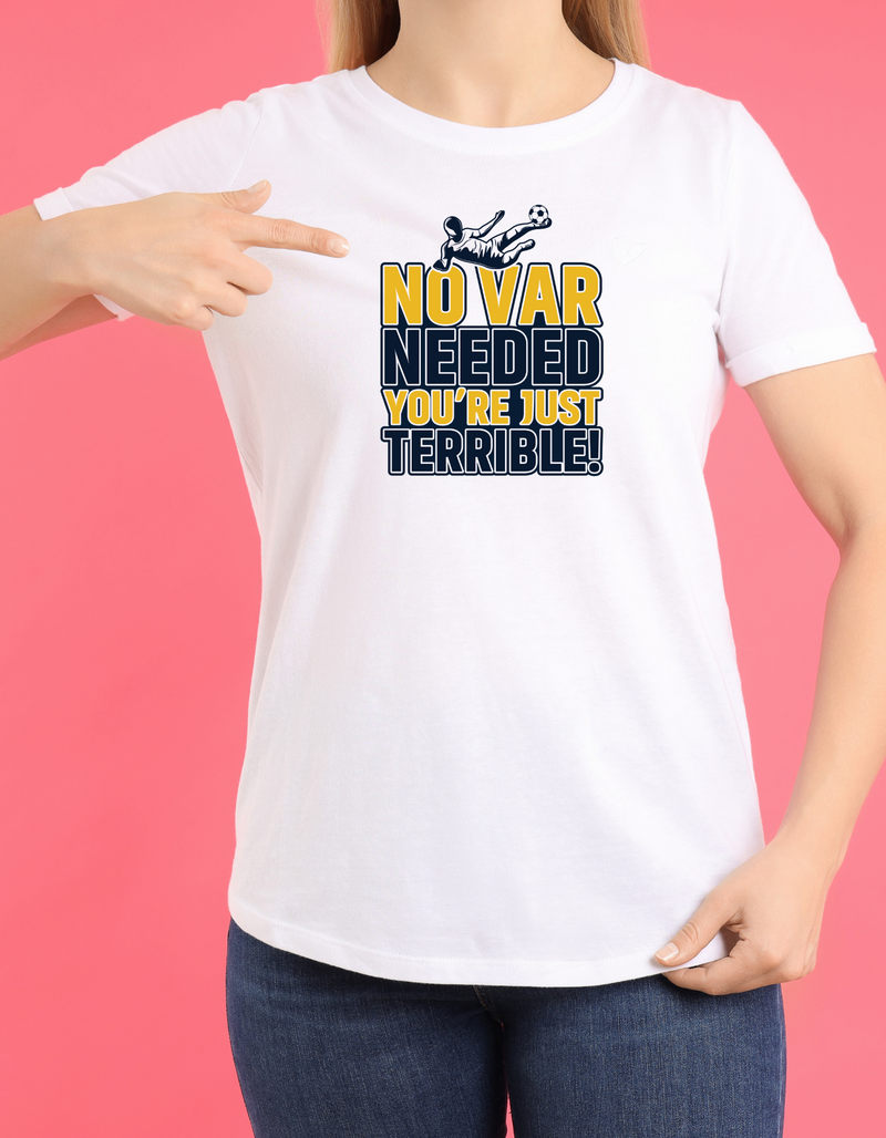 A lady wearing a white t-shirt with the funny football slogan on the front that reads 'No VAR Needed You’re Just Terrible'
