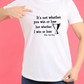 A lady wearing a white t-shirt with the funny tennis slogan on the front reading 'It’s Not Whether You Win or Lose but Whether I Win or Lose – Billie Jean-King!