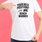A lady wearing a white t-shirt that has the funny football slogan on the front that reads 'Your Best Position? Bench Warmer'