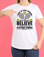 A lady wearing a white t-shirt with funny tennis slogan on the front that reads 'A white ceramic mug with tennis slogan on the front that reads 'I Wake Up Every Morning and Still Can’t Believe I Actually Make a Living Playing Tennis.'