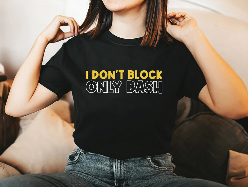 A lady wearing a black t-shirt with I Don't Block, Only Bash on the front. 
 A Funny Cricket Tee, Premium Fabric, Multiple Adult Sizes