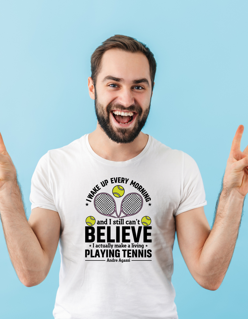 A man wearing a white t-shirt with funny tennis slogan on the front that reads 'A white ceramic mug with tennis slogan on the front that reads 'I Wake Up Every Morning and Still Can’t Believe I Actually Make a Living Playing Tennis.' 