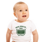 A little baby wearing a white baby grow with the funny football and dad loving slogan on the front which reads 'Messi, Ronaldo…Nah ’My Dads the Real Goat!'