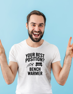 A man wearing a white t-shirt that has the funny football slogan on the front that reads 'Your Best Position? Bench Warmer'
