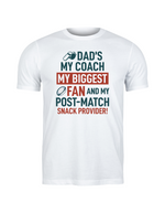 White t-shirt with colorful text design on a white background, with a slogan on the front saying 'Dad’s My Coach My Biggest Fan and My Post-Match Snack Provider!