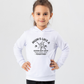 A little girl wearing a white hoodie with Mums Like A Good Bat Grip, Always Holding Things Together on the front. A Funny Cricket T-Shirt, Premium Fabric, Multiple Junior Sizes, Perfect for Boys and Girls