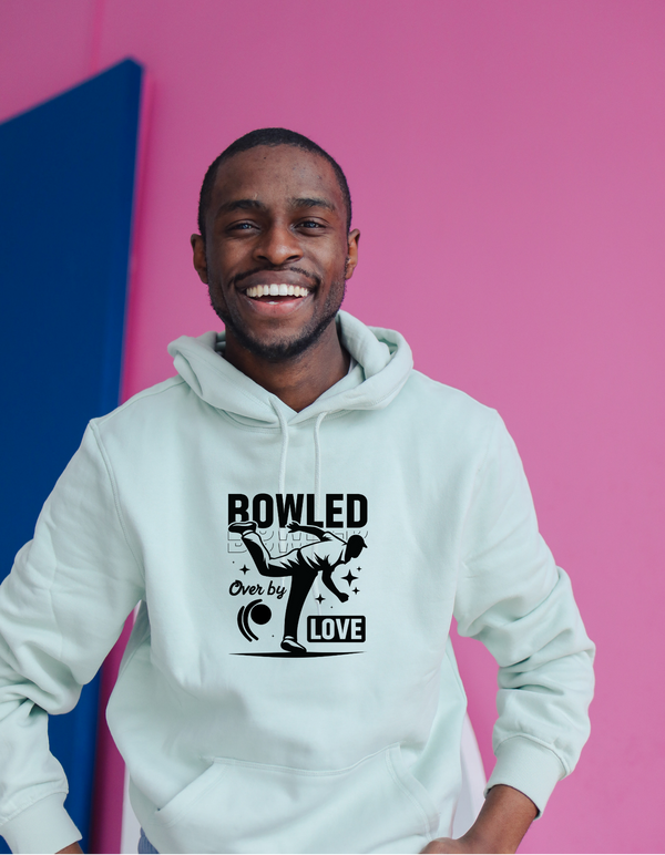 A man wearing a white hoodie with Bowled Over By Love on the front. A Cricket Hoodie.  Funny Cricket Hoodie, Premium Fabric, Multiple Adult Sizes