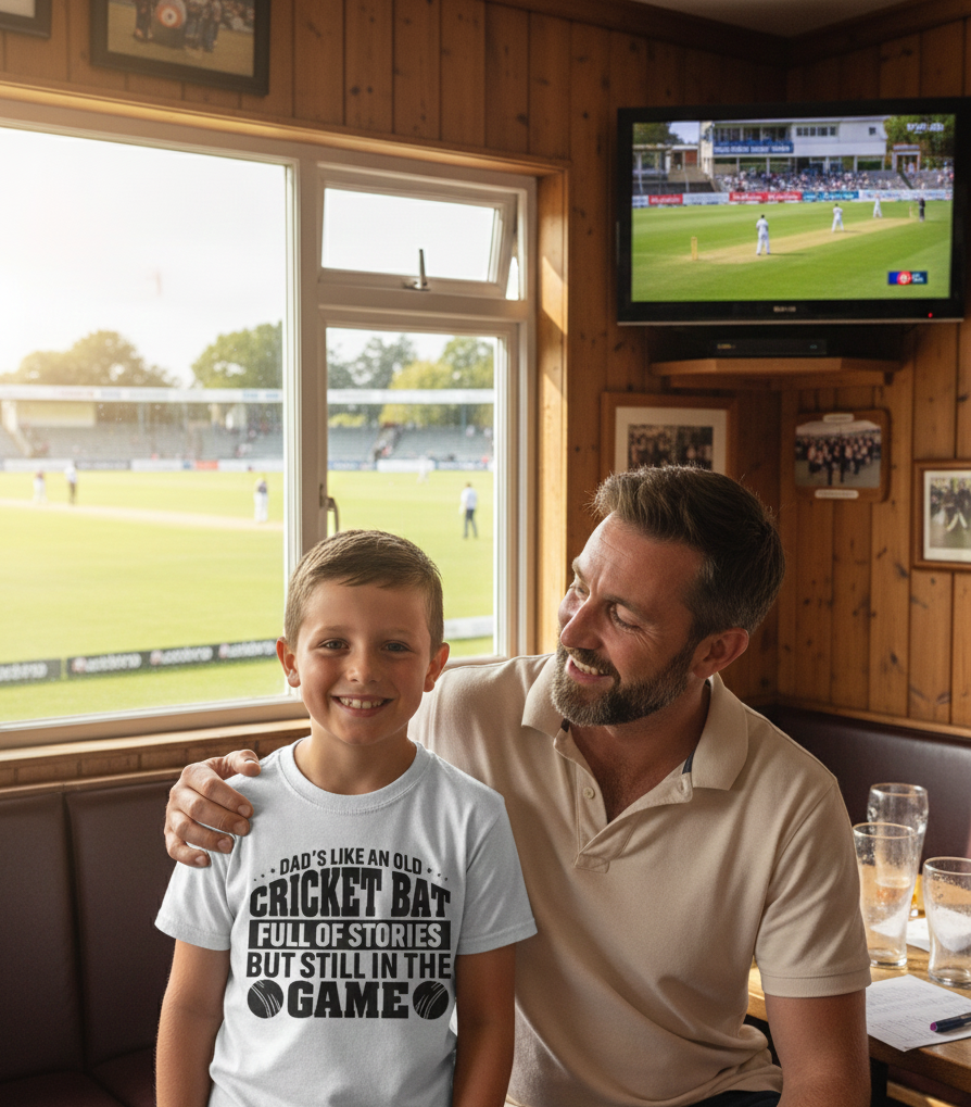 Man and child sitting together in a pub watching cricket on TV with the young boy wearing a Cows Corner t-shirt with the funny slogan on the front saying 'Dads like an old cricket bat, full of stories but still in the game!'  Cows Corner gifts are perfect for sport-mad fans who love a bit of humour and personality in their presents. They’re ideal for friends, partners, parents, coaches, teammates, and proud mums and dads who live and breathe sport, whether they play, watch from the sidelines