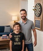 The boy is wearing a Cows Corner t-shirt with the funny darts slogan that reads Bullseyes And Bedtime Stories With Dad.  Cows Corner gifts are perfect for sport-mad fans, these gifts work brilliantly for birthdays, new baby celebrations, Father’s Day, Mother’s Day, Christmas, anniversaries, thank you gifts, end-of-season team awards, graduations, retirements, and just-because moments when you want to raise a smile. 
