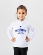 A little girl wearing a white hoodie with Dad's Captain, But I'm The Real Decision-Maker on the front. A Funny Cricket Hoodie, Premium Fabric, Multiple Junior Sizes, Perfect for Boys and Girls