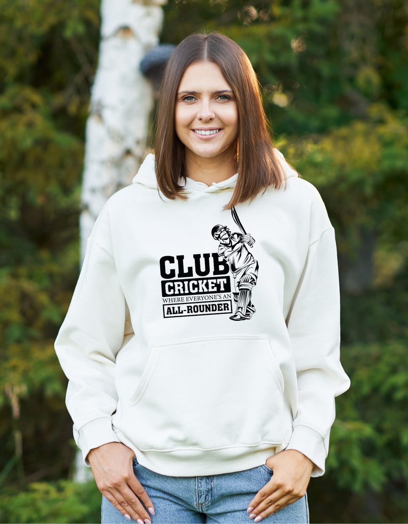 A lady wearing a white hoodie with Funny Cricket Hoodie – 'Club Cricket: Where Everyone’s an All-Rounder' on the front. A Funny Cricket Hoodie, Premium Fabric, Multiple Adult Sizes