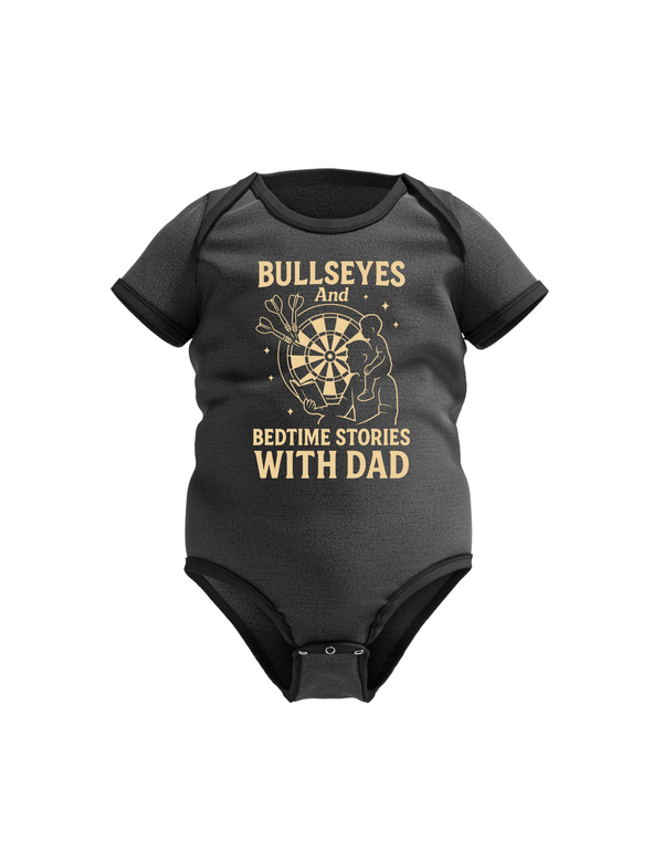 Black baby onesie with gold text and graphic on a white background.  This is a Cows Corner baby grow with the funny darts slogan that reads 'Bullseyes And Bedtime Stories With Dad'.  Cows Corner gifts are perfect for sport-mad fans, these gifts work brilliantly for birthdays, new baby celebrations, Father’s Day, Mother’s Day, Christmas, anniversaries, thank you gifts, end-of-season team awards, graduations, retirements, and just-because moments when you want to raise a smile. 
