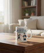 Mug with a graphic and text on a coffee table in a living room setting. This is a Cows Corner mug with a funny cricket slogan 'To My Coach Who Made Me Believe in My First Cover Drive – You’re a Legend'. Cows Corner gifts are perfect for sport-mad fans, these gifts work brilliantly for birthdays, new baby celebrations, Father’s Day, Mother’s Day, Christmas, anniversaries, thank you gifts, end-of-season team awards, graduations, retirements, and just-because moments when you want to raise a smile. 
