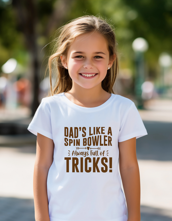A little girl with wearing a Funny Cricket T-Shirt – "Dad’s Like a Spin Bowler, Always Full of Tricks, on the front". A Premium Fabric, Multiple Junior Sizes, Perfect for Boys and Girls