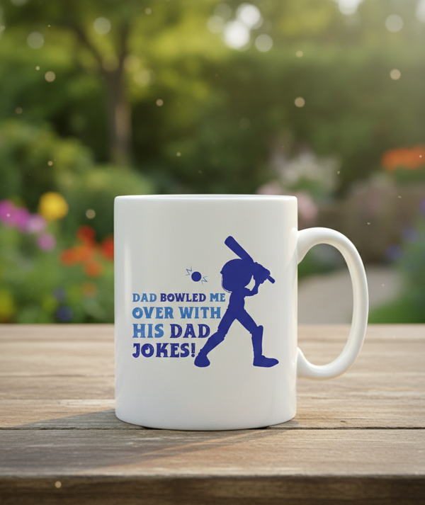White mug with blue text and graphic on a wooden surface with a garden background. This is a Cows Corner mug with a funny cricket slogan 'Dad Bowled Me Over With His Dad Jokes'. Cows Corner gifts are perfect for sport-mad fans, these gifts work brilliantly for birthdays, new baby celebrations, Father’s Day, Mother’s Day, Christmas, anniversaries, thank you gifts, end-of-season team awards, graduations, retirements, and just-because moments when you want to raise a smile. 
