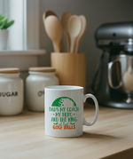 White mug with golf-themed text on a kitchen counter. This is a Cows Corner mug with a funny golf slogan 'Dads My Coach, My Hero and the King of Lost Golf Balls'. Cows Corner gifts are perfect for sport-mad fans, these gifts work brilliantly for birthdays, new baby celebrations, Father’s Day, Mother’s Day, Christmas, anniversaries, thank you gifts, end-of-season team awards, graduations, retirements, and just-because moments when you want to raise a smile. 
