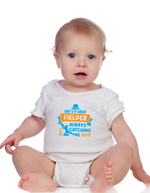 A baby wearing a baby grow with Dad’s a Great Fielder, Always Catching Me Out, on the front. Funny Cricket Baby Bodysuit, Organic or In-Conversion to Organic Cotton, Self Fabric Bound Neckline, Cuffs and Leg Openings