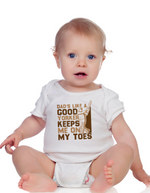 A baby wearing a baby grow with Dad’s Like a Good Yorker, Keeps Me on My Toes, on the front! Funny Cricket Baby Bodysuit, Organic or In-Conversion to Organic Cotton, Self Fabric Bound Neckline, Cuffs and Leg Openings