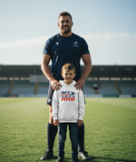Man and child standing on a sports field with a hoodie text.  The boy is wearing a Cows Corner hoodie with the funny rugby slogan 'Dad’s My Hero on and off the Pitch!'. Cows Corner gifts are perfect for sport-mad fans, these gifts work brilliantly for birthdays, new baby celebrations, Father’s Day, Mother’s Day, Christmas, anniversaries, thank you gifts, end-of-season team awards, graduations, retirements, and just-because moments when you want to raise a smile. 
 