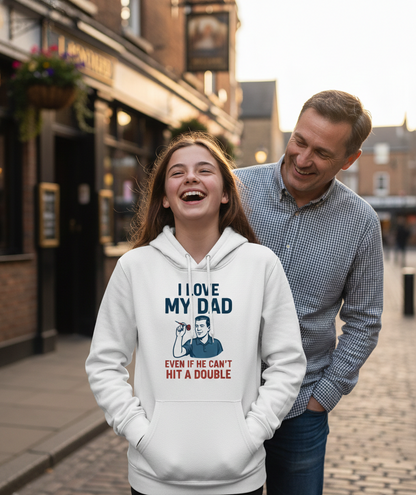 Woman wearing a hoodie with a humorous graphic and text, standing next to a man on a street. The girl is wearing a Cows Corner hoodie with the funny darts slogan 'I Love My Dad… Even If He Can’t Hit A Double'. Cows Corner gifts are perfect for sport-mad fans, these gifts work brilliantly for birthdays, new baby celebrations, Father’s Day, Mother’s Day, Christmas, anniversaries, thank you gifts, end-of-season team awards, graduations, retirements, and just-because moments when you want to raise a smile. 
