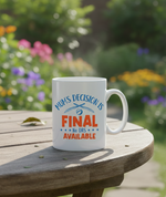 A white Cows Corner mug with 'Mum's Decision is Final, No DRS Available' text on a wooden table with a garden background. Cows Corner gifts are perfect for sport-mad fans, these gifts work brilliantly for birthdays, new baby celebrations, Father’s Day, Mother’s Day, Christmas, anniversaries, thank you gifts, end-of-season team awards, graduations, retirements, and just-because moments when you want to raise a smile. 
