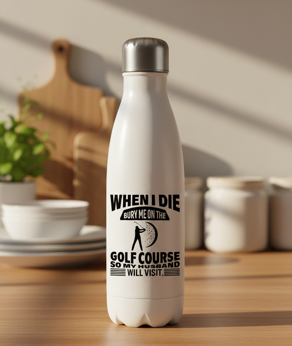 White water bottle with humorous text design on a kitchen counter. This is a Cows Corner water bottle with a funny golf slogan 'When I Die Bury Me on the Golf Course So My Husband Will Visit'. Cows Corner gifts are perfect for sport-mad fans, these gifts work brilliantly for birthdays, new baby celebrations, Father’s Day, Mother’s Day, Christmas, anniversaries, thank you gifts, end-of-season team awards, graduations, retirements, and just-because moments when you want to raise a smile. 
