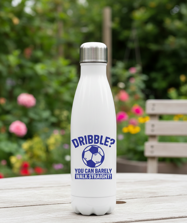 White water bottle with blue text and a soccer ball graphic on a wooden table with a garden background. This is a Cows Corner water bottle with a funny football slogan 'Dribble You Can Barely Walk Straight!'. Cows Corner gifts are perfect for sport-mad fans, these gifts work brilliantly for birthdays, new baby celebrations, Father’s Day, Mother’s Day, Christmas, anniversaries, thank you gifts, end-of-season team awards, graduations, retirements, and just-because moments when you want to raise a smile. 
