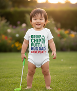 Child wearing a onesie with golf-themed text in a garden setting. The baby is wearing a Cows Corner baby grow with a funny golf slogan 'Drive Chip Putt Hug Dad Repeat!'. Cows Corner gifts are perfect for sport-mad fans, these gifts work brilliantly for birthdays, new baby celebrations, Father’s Day, Mother’s Day, Christmas, anniversaries, thank you gifts, end-of-season team awards, graduations, retirements, and just-because moments when you want to raise a smile. 
