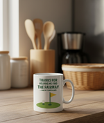 White mug with a golf-themed design on a wooden surface in a kitchen  setting. This is a Cows Corner mug with a funny golf slogan 'Thanks for Helping Me for the Fairway – and My Confidence'. Cows Corner gifts are perfect for sport-mad fans, these gifts work brilliantly for birthdays, new baby celebrations, Father’s Day, Mother’s Day, Christmas, anniversaries, thank you gifts, end-of-season team awards, graduations, retirements, and just-because moments when you want to raise a smile. 

