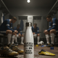 White insulated bottle with text in a sports changing room.  White water bottle with text on a sports field. Cows Corner funny birthday present water bottle with funny slogan 'your best position?  Bench warmer!  Cows Corner gifts are perfect for sport-mad fans, these gifts work brilliantly for birthdays, new baby celebrations, Father’s Day, Mother’s Day, Christmas, anniversaries, thank you gifts, end-of-season team awards, graduations, retirements, and just-because moments when you want to raise a smile. 