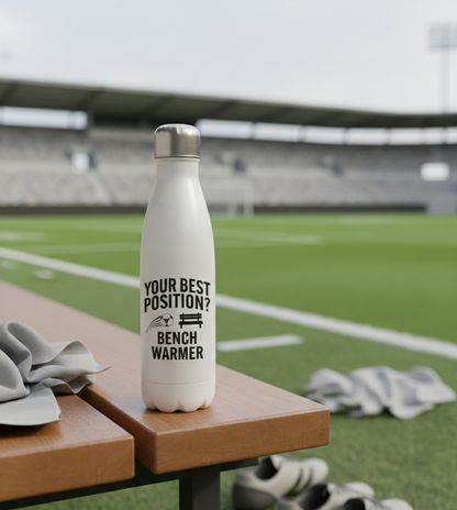 White water bottle with text on a sports field. Cows Corner funny birthday present water bottle with funny slogan 'your best position?  Bench warmer!  Cows Corner gifts are perfect for sport-mad fans, these gifts work brilliantly for birthdays, new baby celebrations, Father’s Day, Mother’s Day, Christmas, anniversaries, thank you gifts, end-of-season team awards, graduations, retirements, and just-because moments when you want to raise a smile. 