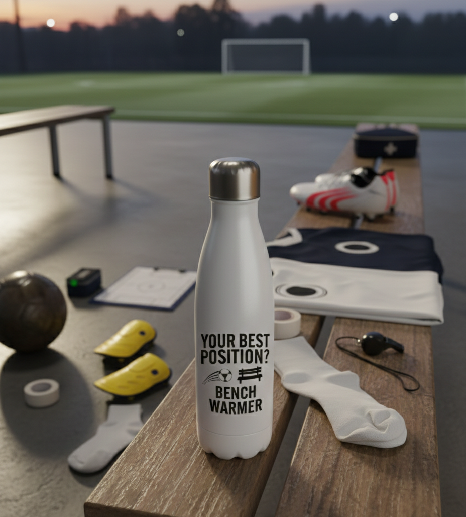 White water bottle with 'Your best position? Bench Warmer' text on a sports field background. Cows Corner gifts are perfect for sport-mad fans, these gifts work brilliantly for birthdays, new baby celebrations, Father’s Day, Mother’s Day, Christmas, anniversaries, thank you gifts, end-of-season team awards, graduations, retirements, and just-because moments w
